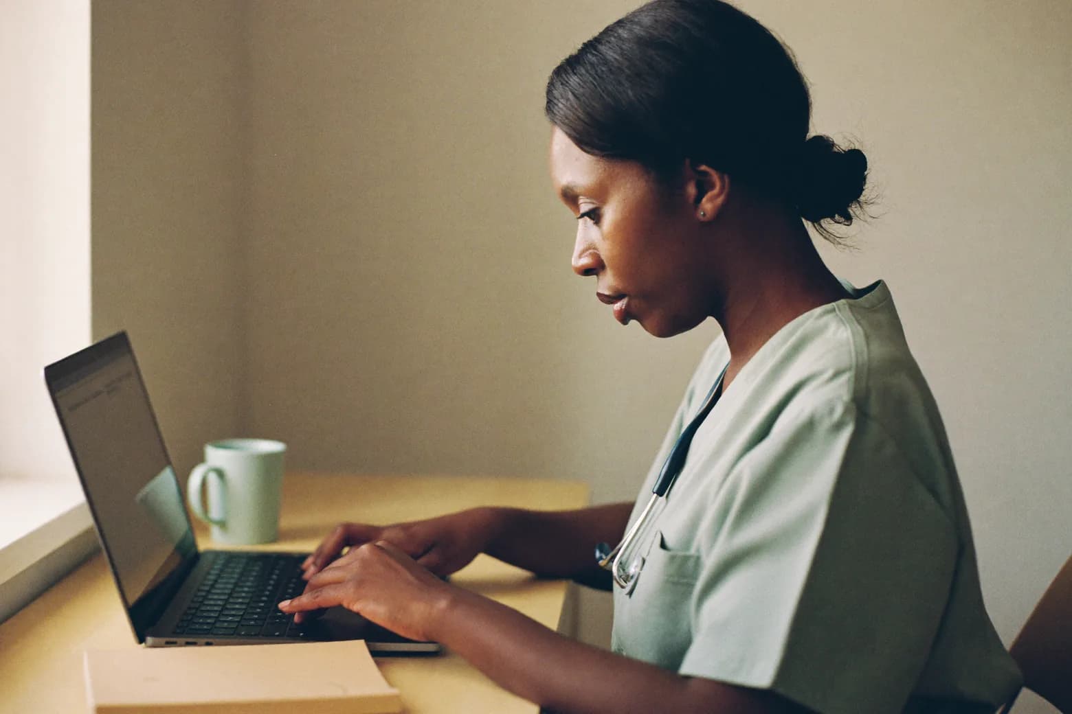 A person works at a laptop at a desk.